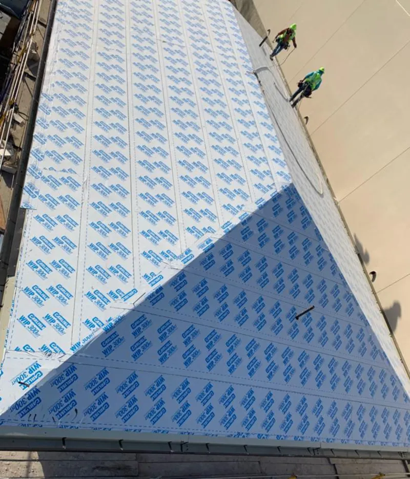 Professional roofers installing underlayment on a metal roof in Mills River